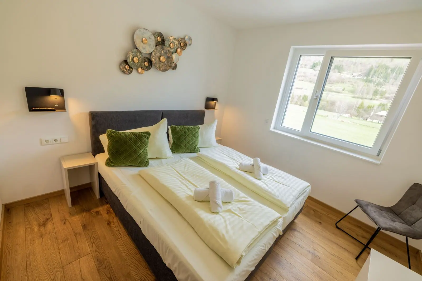 Slaapkamer met tweepersoonsbed en raam naar de bergen