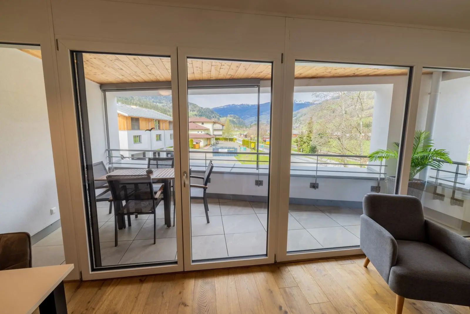 Schuifpui naar het overdekte balkon met tafel en vier stoelen