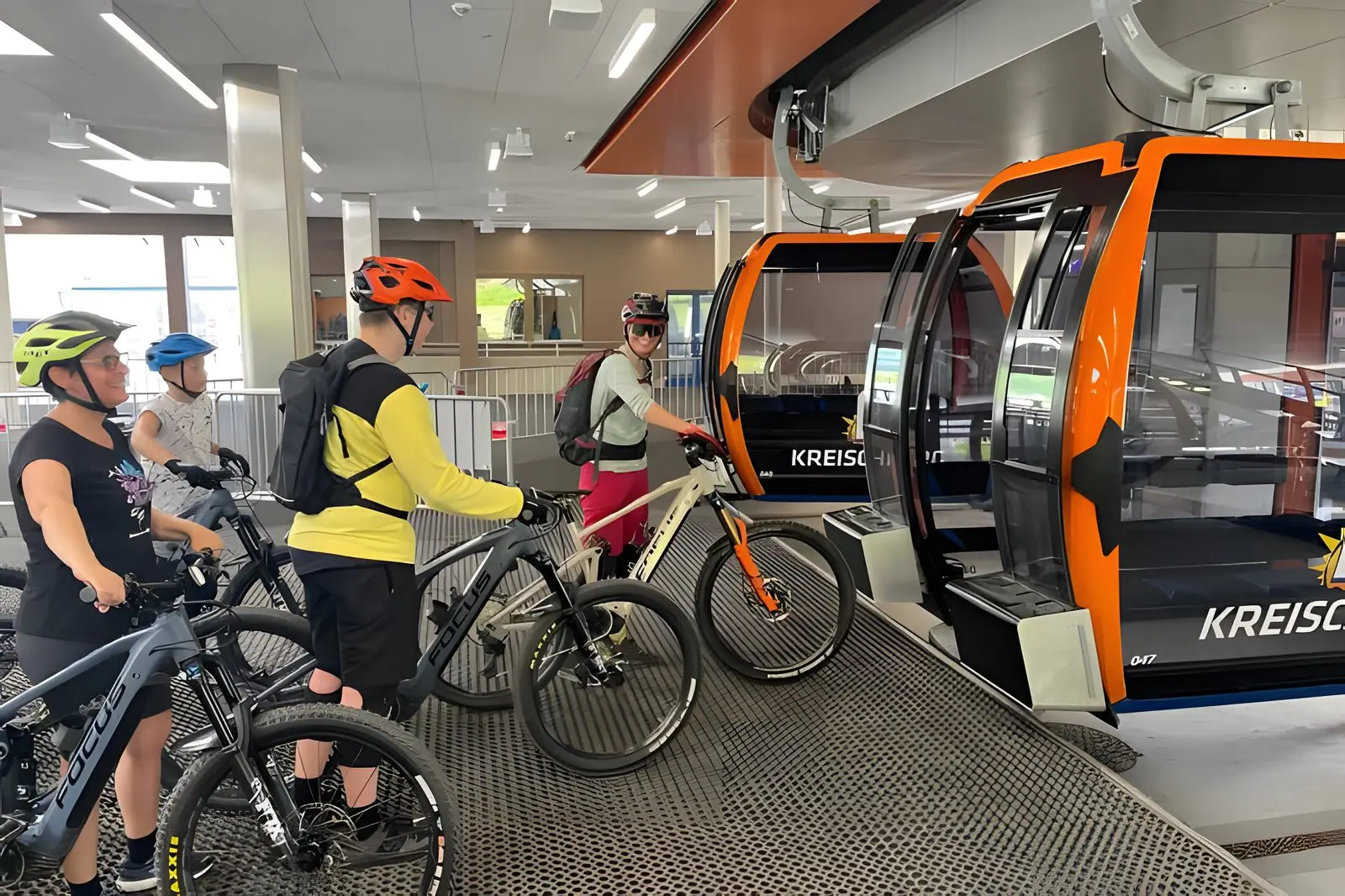 Mountainbikers met hun fietsen bij de gondel van de Kreischberg in het dalstation